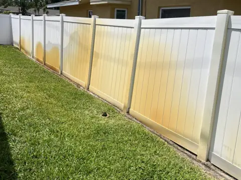 Long run of vinyl fencing with heavy irrigation rust staining